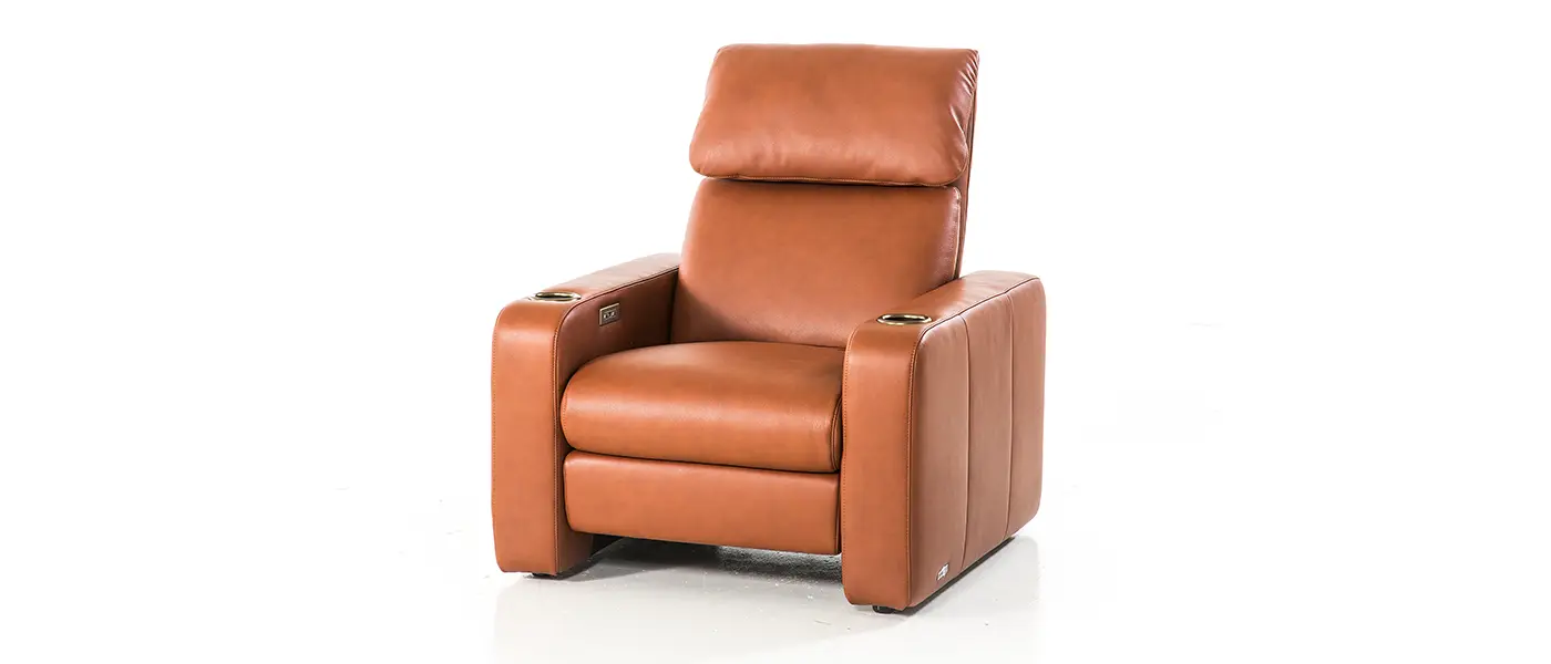 Single luxury recliner in rich caramel-colored leather, featuring a plush, adjustable headrest and streamlined armrests. The chair includes built-in metallic cup holders on each armrest, blending functionality with elegant design. Its minimalist structure and premium upholstery make it an ideal choice for sophisticated home theaters, providing both comfort and style.